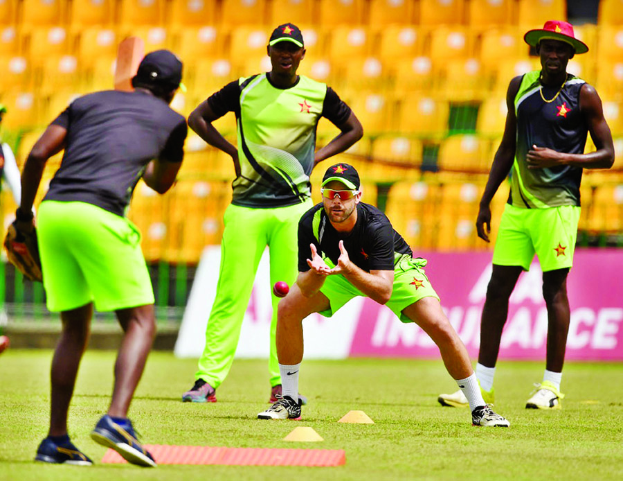 Zimbabwe's cricketer Ryan Burl (2R) catches the ball as teammates look on during a practice session at the R. Premadasa Cricket Stadium in Colombo on Thursday. Sri Lanka and Zimbabwe will play a one-off Test match starting today at the R Premadasa Cricke
