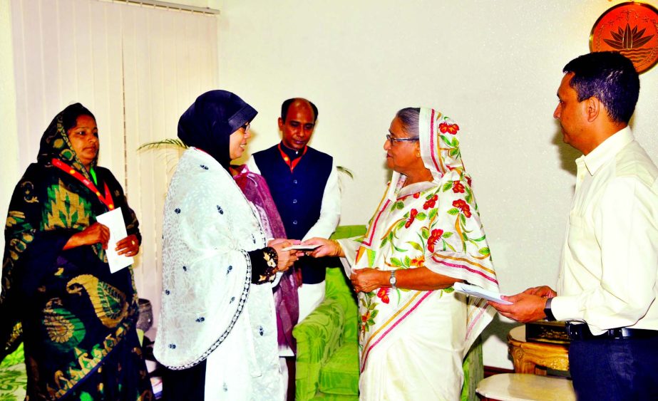 Prime Minister Sheikh Hasina handing over cheques to four families including Nurjahan Begum, victim of Jamaat-Shibir attack in 2014 at Shibganj of Chapainawabganj at her office on Thursday.