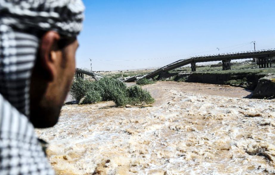 A member of the US-backed Syrian Democratic Forces looks at a damaged bridge in eastern Raqa on Friday during an offensive to retake the city from the Islamic State group.