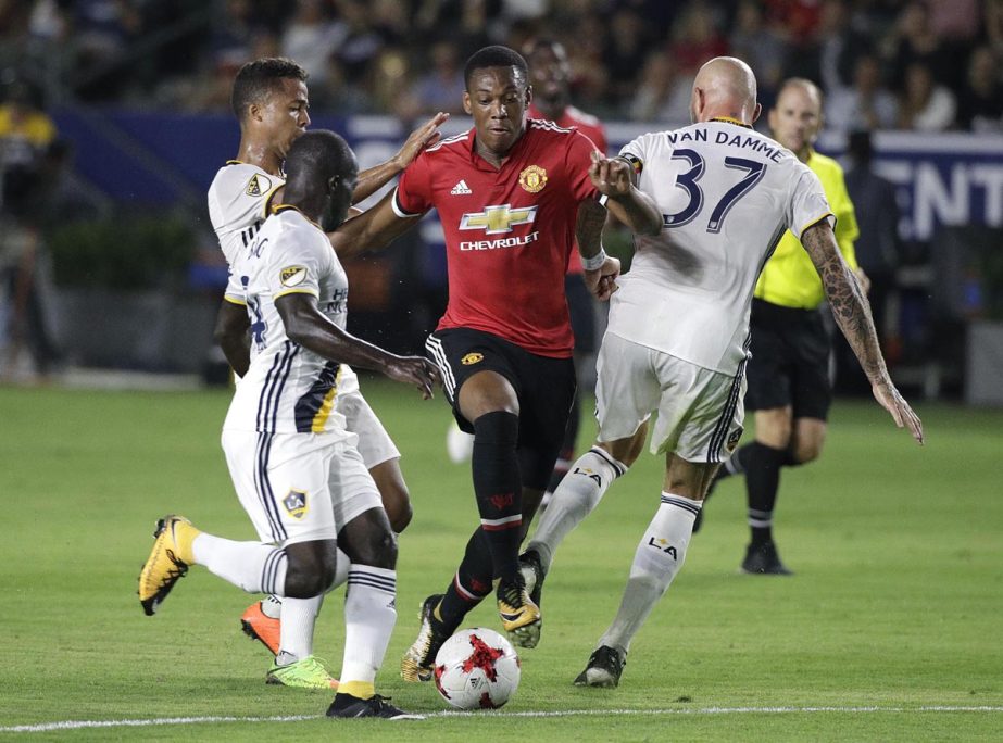 Manchester United's Anthony Martial (center) is pressured by Los Angeles Galaxy's Jelle Van Damme (right), Ema Boateng (front) and Giovani dos Santos during the second half of a friendly soccer match in Carson, Calif. on Saturday. Manchester United won