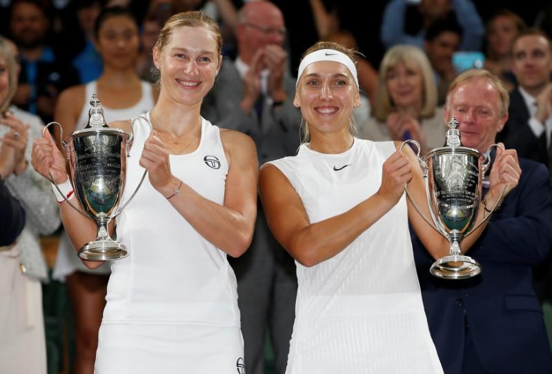 Russia's Ekaterina Makarova and Russia's Elena Vesnina pose as they celebrate with their trophies after winning the women's doubles final against Taiwan's Hao-Ching Chan and Romania's Monica Niculescu at the Wimbledon Tennis Championships in London o