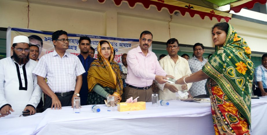 CCC Mayor A J M Nasir Uddin distributing financial assistance among the tornado victims of Ward No 9 at Pahartoli Girls' School and College on Sunday.