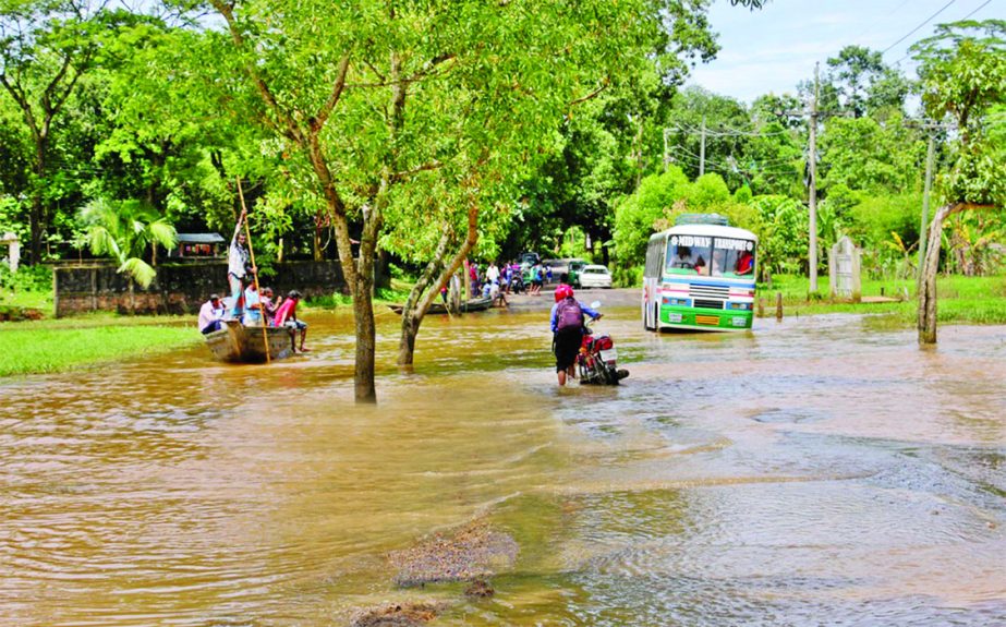 Though floodwaters in Moulvibazar district receding fast, but some areas including main thoroughfare remain submerged, people bound to travel by boat on the street. This photo was taken from Barolekha Upazila area of the district on Monday.