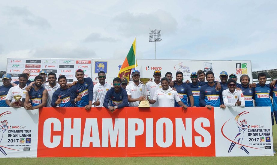 Sri Lankan cricketers pose for photographers after victory in the final day of a one-off Test match between Sri Lanka and Zimbabwe at the R Premadasa Cricket Stadium in Colombo on Tuesday.