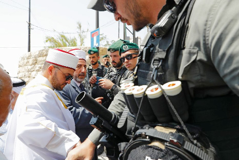 Palestinian Muslim leaders speak with Israeli border guards outside Jerusalem's Al-Aqsa mosque compound on Friday after Israel barred men under 50 from entering the Old City for Friday prayers.