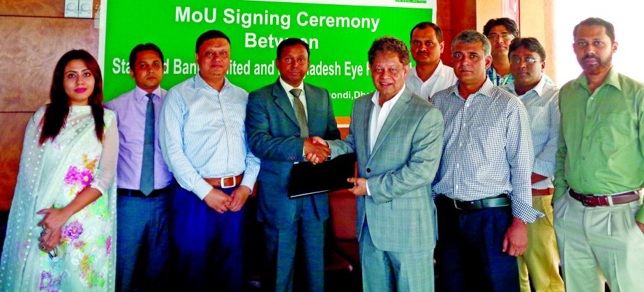 Sharif Zahirul Islam, Head of Cards of Standard Bank Limited and Dr. Niaz Abdur Rahman, Managing Director of Bangladesh Eye Hospital Ltd, sign an agreement at the hospital on Thursday. Dr. Mahbubur Rahman Chowdhury, Chairman of the hospital was present. U