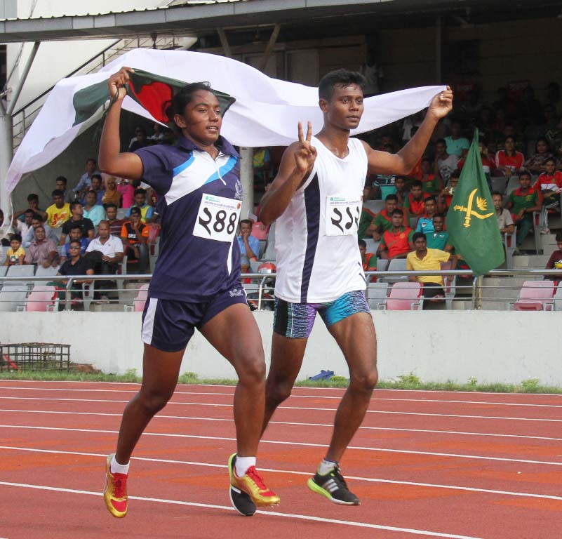 Shirin Akhter (left) of Bangladesh Navy and Mesbah Ahmed of Bangladesh Navy, the fastest woman and the fastest man of NRB Commercial Bank 13th National Summer Athletics Competition pose for photograph after winning their respective 100 metre sprint at the