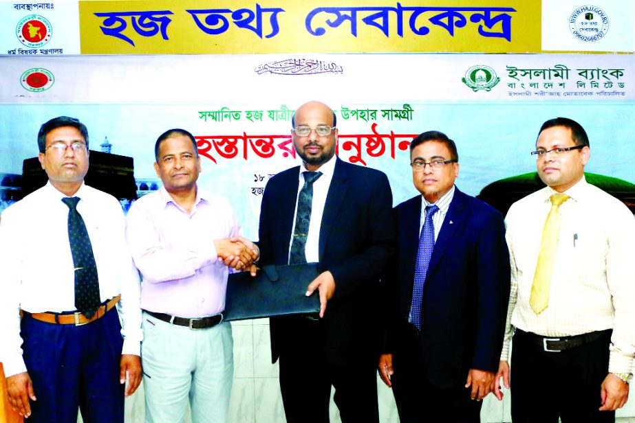 Abu Reza Md Yeahia, Deputy Managing Director and Head of Development Wing of Islami Bank Bangladesh Limited, handing over bed foam with cover for pilgrims to Md Saiful Islam, Deputy Secretary of Religious Affairs Ministry at Ashkona hajj office onTuesday.