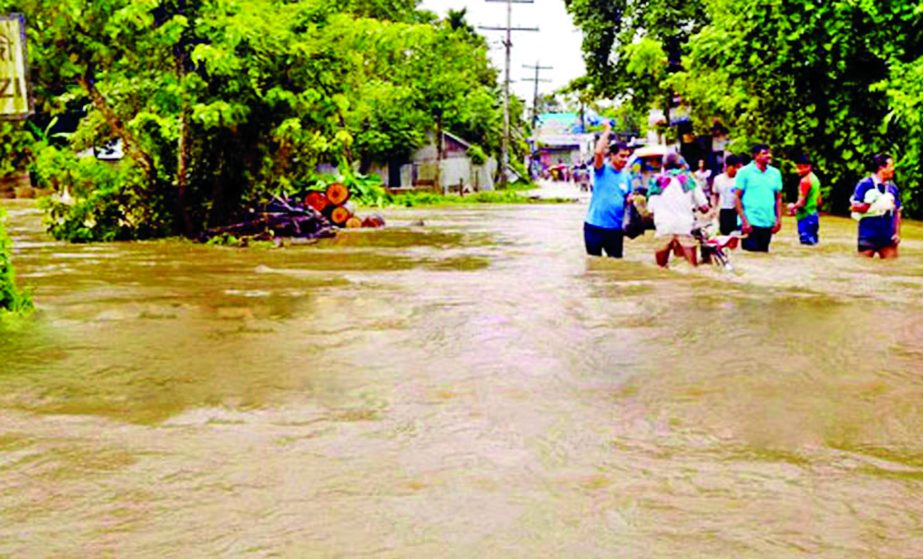 At least 26 villages were inundated triggered by the onrush of waters from upstream and incessant rains. Photo shows Feni to Parashuram main thoroughfare now under the knee to waist deep water causing sufferings to commuters and local dwellers. The photo
