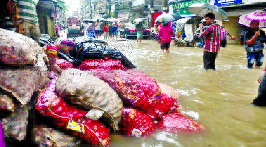 Most of the low-lying areas in Chittagong Port city were inundated under knee-deep to waist-deep water due to heavy downpour for the last two days, causing sufferings to city dwellers. This photo was taken from Khatunganj Market on Monday.