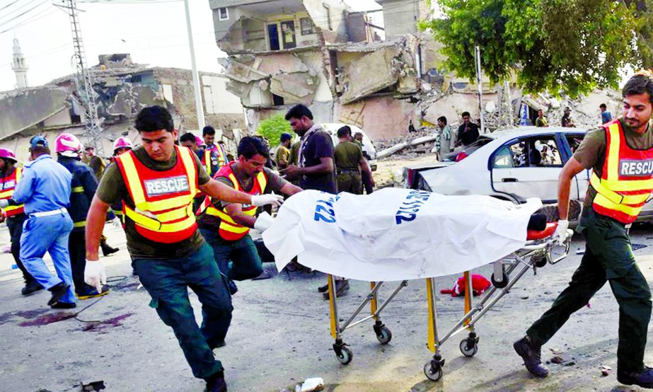 Rescue workers move the body of a victim at the site of an explosion in Lahore.