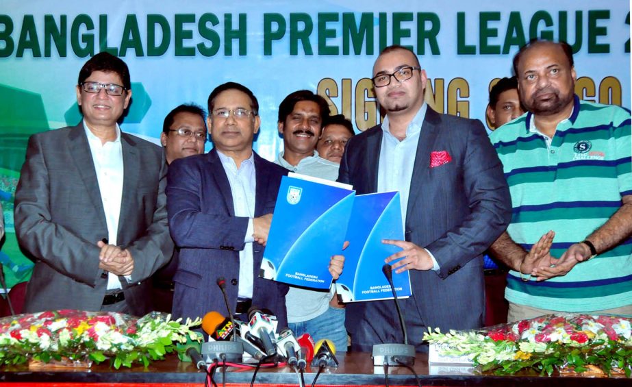Senior Vice-President of Bangladesh Football Federation Abdus Salam Murshedy and Director of Saif Global Sports Tarafder Md Ruhul Saif exchanging papers after signing an agreement at the conference room of BFF House on Tuesday.