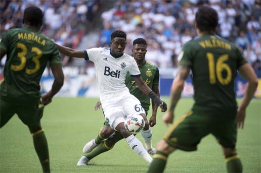 Portland Timbers forward Dairon Asprilla (second from right) gives chase as Vancouver Whitecaps forward Alphonso Davies (67) tries to get the ball around the Timbers' defense during the second half of MLS soccer game action in Vancouver, British Columbia