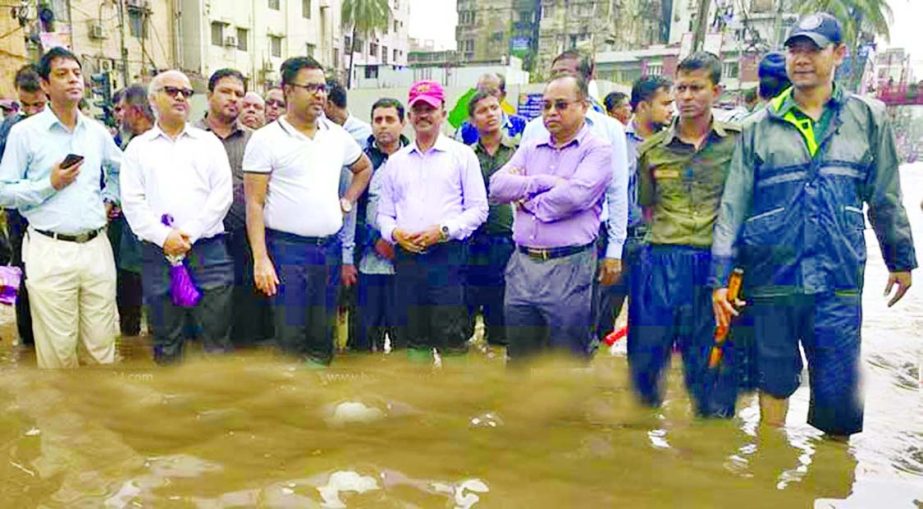 Local elite of Dhanmandi area protest waterlogging by standing in knee deep water on the road in front of Rapa Plaza yesterday.