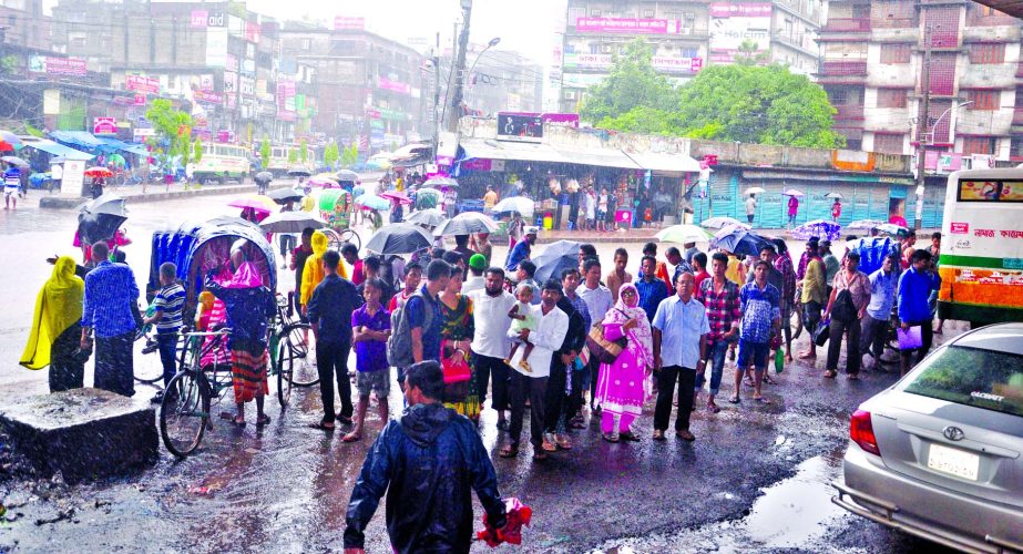 Home-going passengers waiting for several hours due to lack of transports as waterlogging created all over the capital. This photo was taken from Jatrabari area on Wednesday.