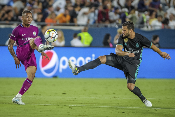 Manchester City's Gabriel Jesus (left) tries to control the ball as Real Madrid CF "Isco"" keeps up the pressure during Wednesday night's soccer match at the Los Angeles Memorial Coliseum in Los Angeles on Wednesday."