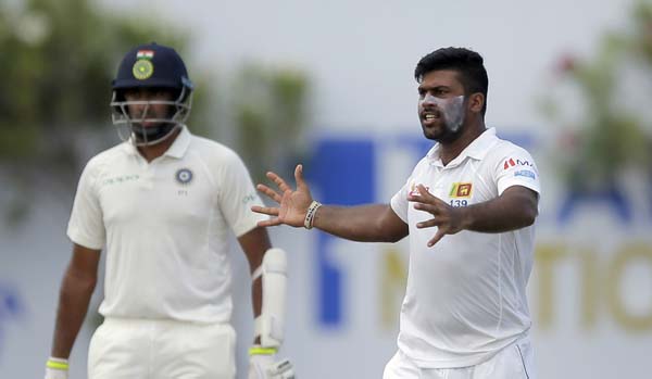 Sri Lanka's bowler Lahiru Kumara (right) celebrates the dismissal of India's Ajinkya Rahane as non striker Cheteshwar Pujara watches during the second day's play of the first Test cricket match between India and Sri Lanka in Galle, Sri Lanka on Thursda