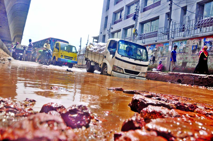 With the recession of waters from the city roads, several potholes, cracks developed, causing sufferings to commuters as vehicles facing difficulties to cross the water-logging area. This photo was taken from Jatrabari area on Thursday.