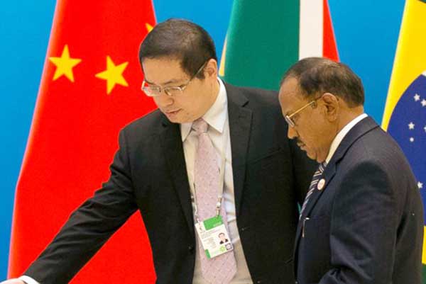 Indian National Security Advisor Ajit Doval, right is shown the way to this position before the seventh meeting of BRICS senior representatives on security issues held at the Diaoyutai state guesthouse near front back to camera in Beijing, China on Friday