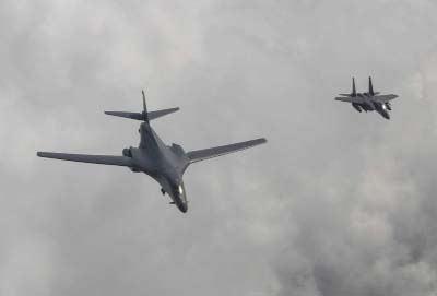 A U.S. Air Force B-1B bomber, left, flies with a South Korean fighter jet F-15K over the Korean Peninsula, South Korea on Sunday