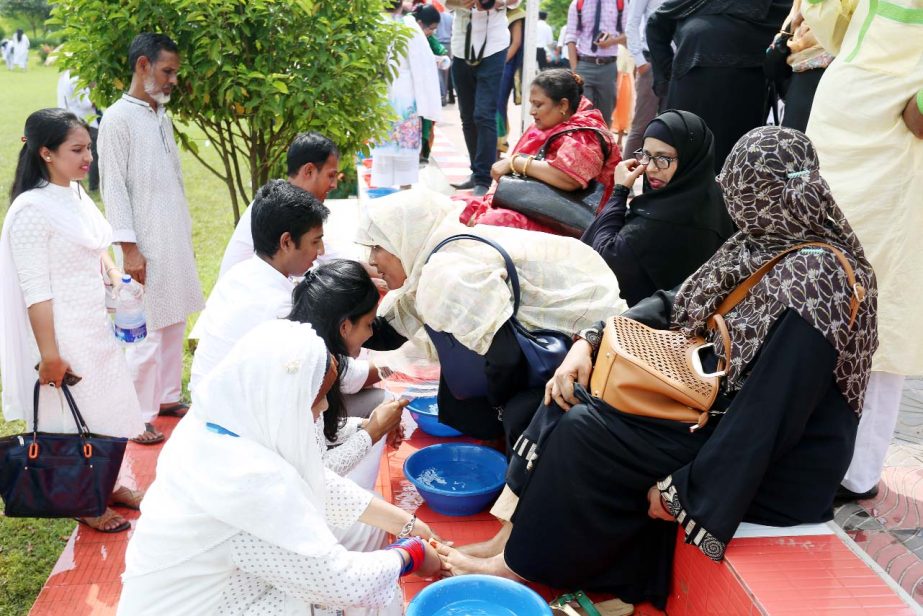 Students of Daffodil International University washing the feet of their parents promising to stay beside them at their older age to mark the â€˜Parents Dayâ€™ observed at the permanent campus of the University on Friday .