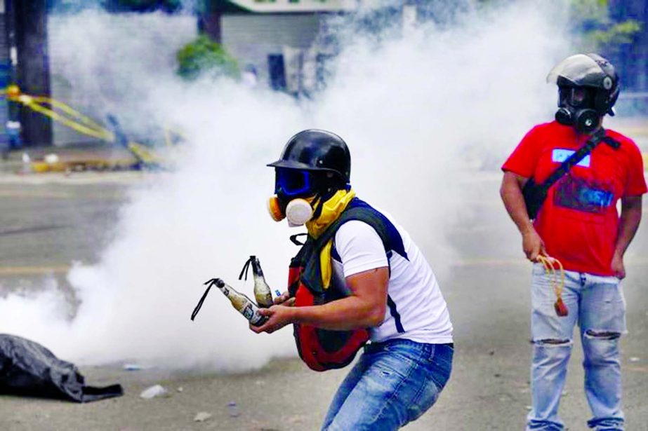 A demonstrator prepares Molotov cocktails as clashes break out while the Constituent Assembly election is being carried out in Caracas, Venezuela.