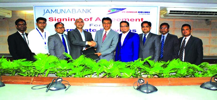 AKM Saifuddin Ahamed, DMD, Jamuna Bank Limited and Sohail Majid, Deputy Director (Marketing & Sales) of US-Bangla Airlines Ltd, exchanging an agreement signing documents at the bankâ€™s head office in the city recently. Under the deal, employees and