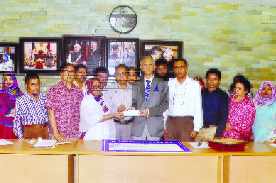 Hasina Akter wife of former Principal Laboratory Instructor of Dhaka University late Shahid Ullah handing over a cheque of Tk 10 lakh to DU Vice-Chancellor Prof Dr AAMS Arefin Siddique at the latter's office on Monday to introduce 'Shahid Ullah Gold Med