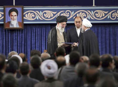 Iranian Supreme leader Ayatollah Ali Khamenei, left, gives his official seal of approval to President Hassan Rouhani as deputy chief of supreme leader's office Vahid Haghanian looks on in an endorsement ceremony in Tehran on Thursday .