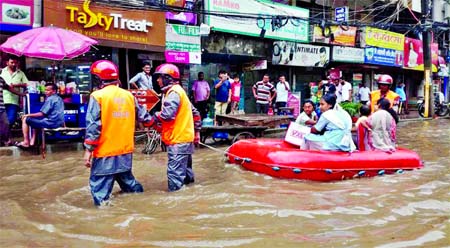 Fire Service workers helping the stranded people from waterlogging area through rubber boat as heavy rains made all the capital streets worse for the second day on Thursday. This photo was taken from Shantinagar area on Thursday.