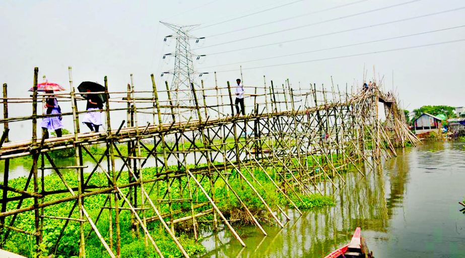 People of the capital Dhaka's Khilgaon and Demra area crossing the river Balu using bamboo bridge since long taking risk of life. This photo was taken from Itakhola in Demra area on Saturday.