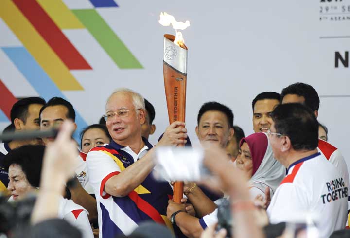 Malaysian Prime Minister Najib Razak (center left) passes the torch to a participant during the torch run for the upcoming Southeast Asian Games in Kuala Lumpur, Malaysia, Sunday. Kuala Lumpur will be the host city of the 29th SEA Games and the 9th ASEAN