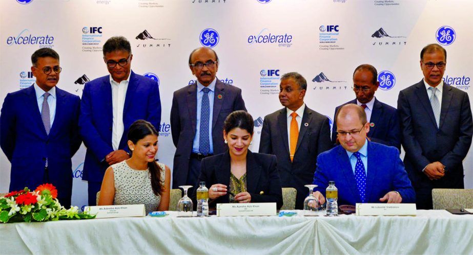 Faisal Khan, Additional Managing Director of Summit Corporation and Banmali Agrawala, CEO of GE South Asia, inks a deal for power generation and LNG supply at a city auditorium on Sunday. Tariqur Rashid, Managing Director of SLTC and Karlman Tham, General