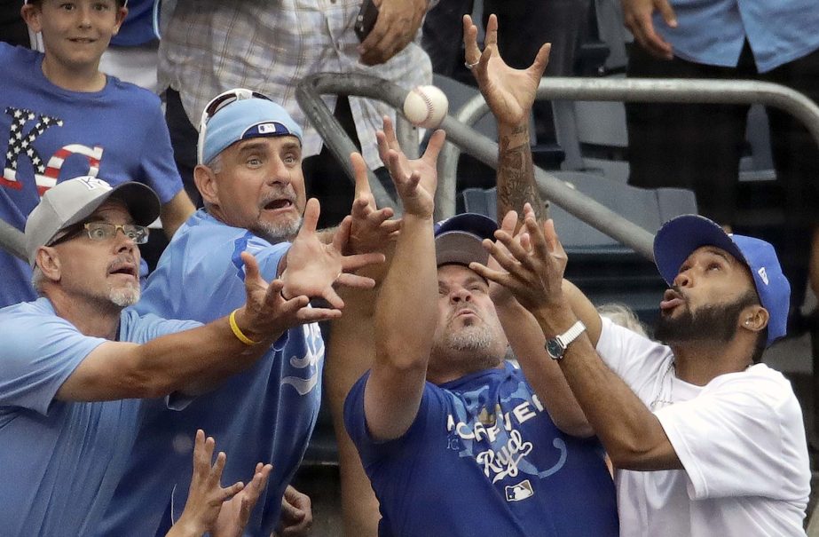 Fans try for a foul ball hit by Kansas City Royals' Melky Cabrera during the seventh inning of the second baseball game in a doubleheader against the Seattle Mariners in Kansas City, Mo on Sunday.