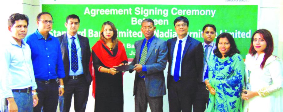 M Ahsan Ullah Khan, Head of Public Relation Dept. of Standard Bank Ltd, and Sadia Afrin, Director of Nadia Furniture Limited exchanging an agreement signing documents at the banks head office in the city recently. Under the deal, VISA cardholders and empl