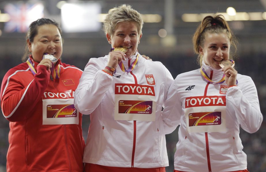 Poland's gold medal winner Anita Wlodarczyk is flanked by China's silver medal winner Wang Zheng (left) and Poland's bronze medal winner Malwina Kopron during the ceremony for the women's hammer throw final at the World Athletics Championships in Lond