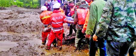 Rescue workers carry an injured villager at the site of a landslide that occurred in Gengdi village, Puge county, Sichuan province, China on Tuesday.