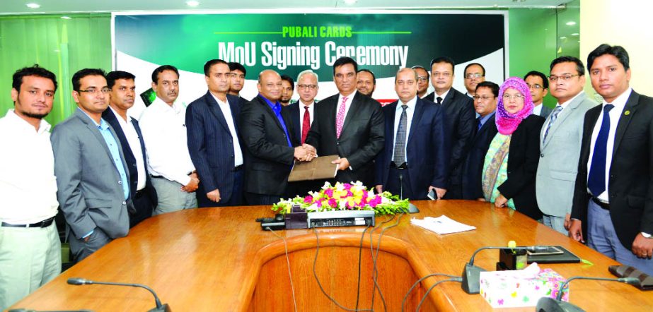 Md. Abdul Halim Chowdhury, Managing Director of Pubali Bank Limited and Md Shakil Choudhury, General Manager of Transcom Electronics Ltd, exchanging a MoU signing documents at the banks' head office in the city recently. Under the deal, Credit and Debit