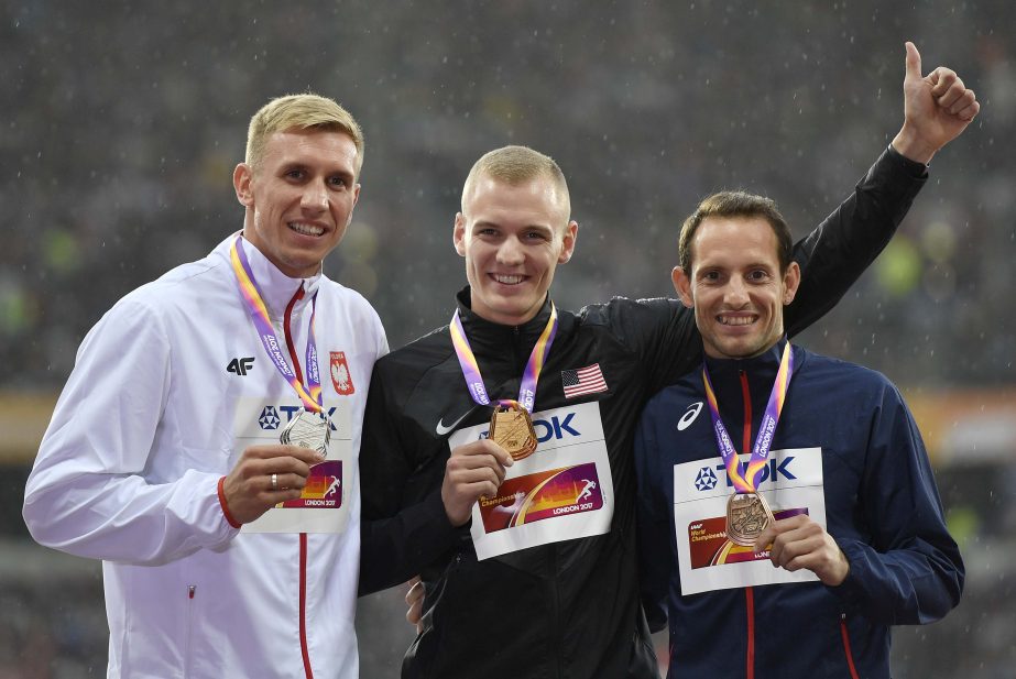 Men's pole vault gold medalist United States' Sam Kendricks (centre) stands with silver medalist Poland's Piotr Lisek (left) and bronze medalist France's Renaud Lavillenie on the podium following the medal ceremony at the World Athletics Championships