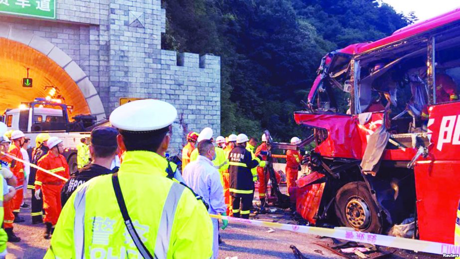 Police and firefighters work near the wreckage of a coach after it crashed into the wall of a tunnel along the Xi'an-Hanzhong expressway in Ankang, Shaanxi province in China on Friday.