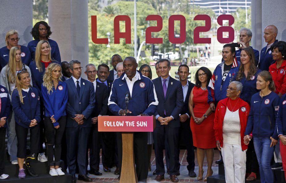 Olympic champions Carl Lewis, holder of nine Olympic gold medals in track and field joins Los Angeles Mayor Eric Garcetti (right) at podium, and city officials and former Olympians at a news conference after the City Council members voted 12-0 to endorse
