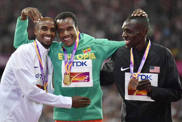 Men's 5000 meters gold medalist Ethiopia's Muktar Edris (centre) stands with silver medalist Britain's Mo Farah (left) and bronze medalist United States' Paul Kipkemoi Chelimo (right) on the podium following the medal ceremony at the World Athletics C