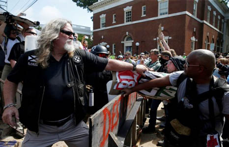 A white supremacist grabs a counter protesters' sign during a rally in Charlottesville, Virginia, U.S.