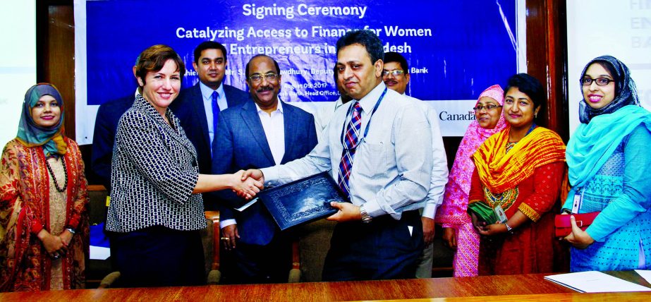Wendy J Werner, Country Director of International Finance Corporation (IFC), a wing of the World Bank Group and Nawshad Mustafa, Joint Director of Bangladesh Bank exchanging an agreement signing documents at the bank's head office in the city recently. U