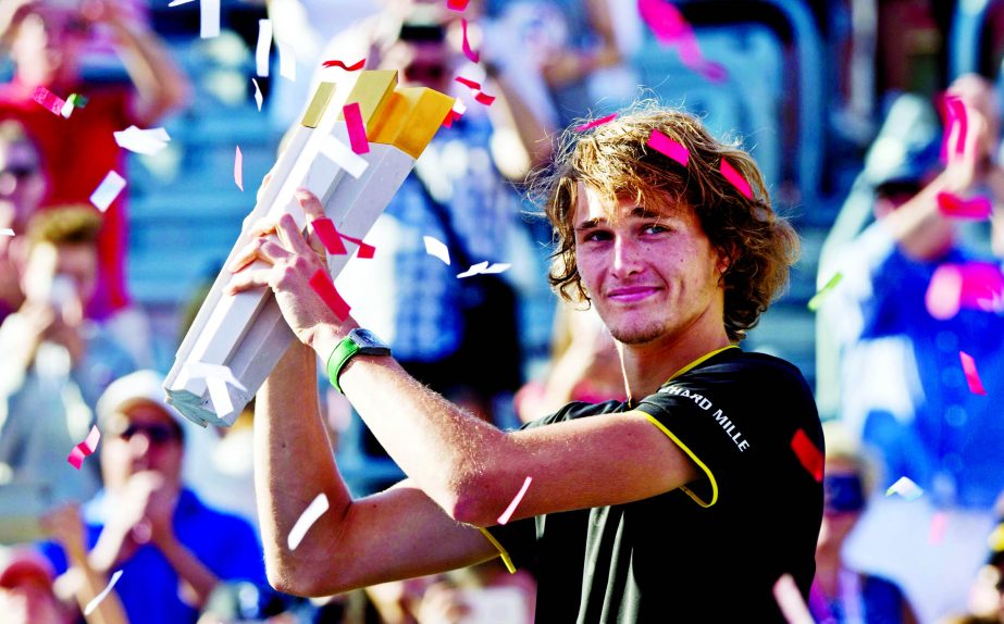 Alexander Zverev of Germany holds up the winner's trophy after defeating Roger Federer of Switzerland in the final at the Rogers Cup tennis tournament in Montreal on Sunday.