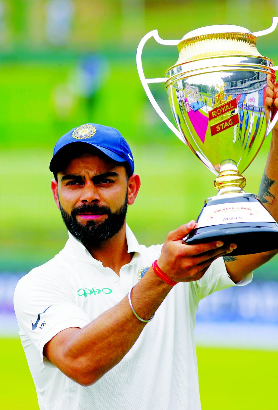 India's captain Virat Kohli holds the winners trophy after their win over Sri Lanka in the third cricket Test match in Pallekele, Sri Lanka on Monday.