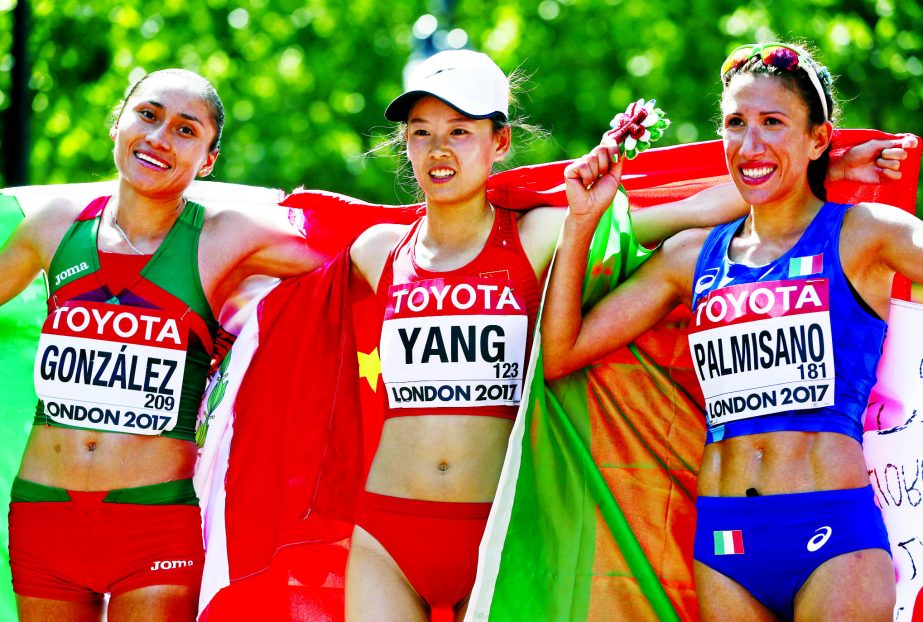 China's gold medal winner Yang Jiayu is flanked bu Mexico's silver medal winner Maria Guadalupe Gonzalez (left) and Italy's bronze medal winner Antonella Palmisano after the women's 20-kilometer race walk during the World Athletics Championships in Lo