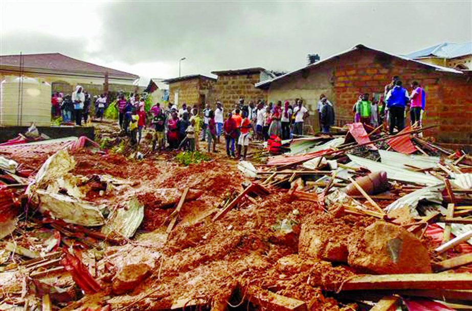 Residents of Freetown survey the damage caused by the mudslide in the suburb of Regent behind Guma reservoir Sierra Leone.