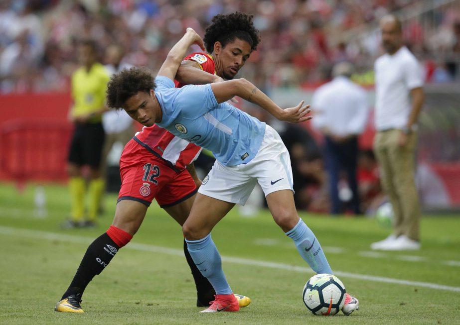 Manchester City's Leroy Sane (right) duels for the ball against Girona's Douglas Luiz during the Costa Brava trophy friendly soccer match between Girona and Manchester City at the Montilivi stadium in Girona, Spain on Tuesday