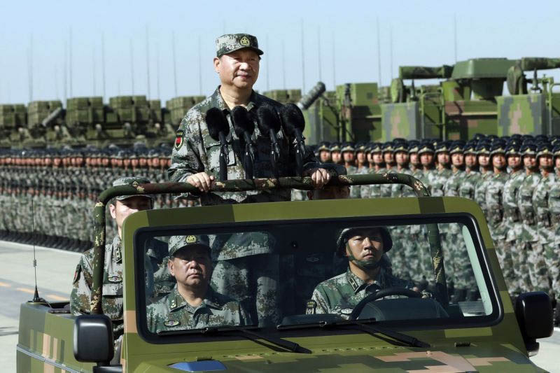 Chinese President Xi Jinping stands on a military jeep as he inspects troops of the People's Liberation Army during a military parade to commemorate the 90th anniversary of the founding of the PLA at Zhurihe training base in north China's Inner Mongolia